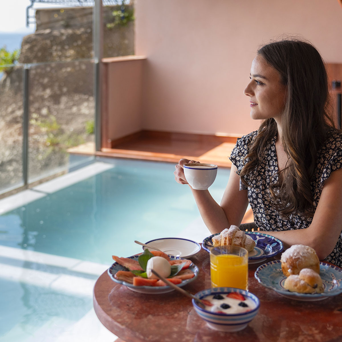 ragazza fa colazione mentre guarda il mare su una terrazza di laqua by the sea